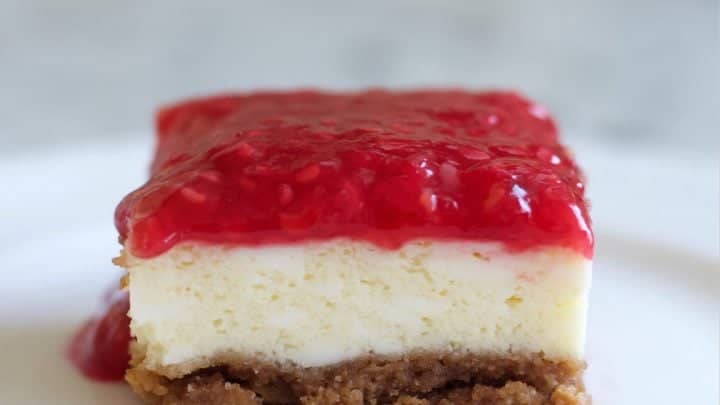 Raspberry Cheesecake square cut on a plate.