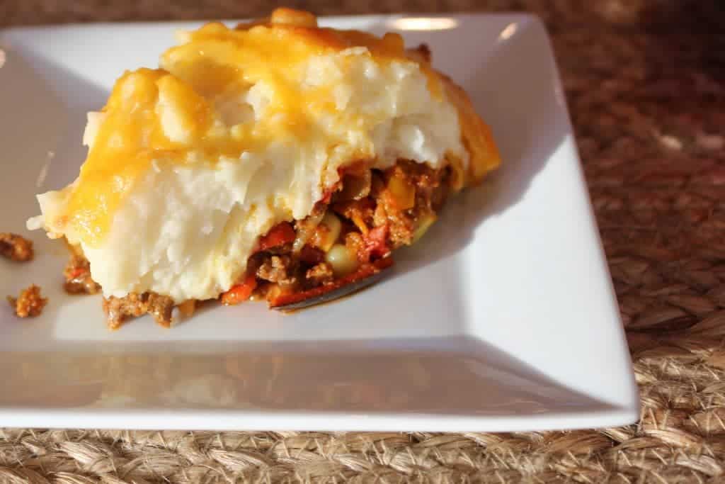 Shepherd's pie has a hamburger filling spiced with a southwestern flair, topped with creamy mashed potatoes and melted shredded cheese. A comforting, filling casserole. https://homemadefoodjunkie.1wp.site