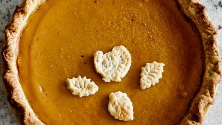 Pumpkin pie filling from fresh pumpkins baked in a sourdough pie crust with a turkey and three fall leaf dough toppers