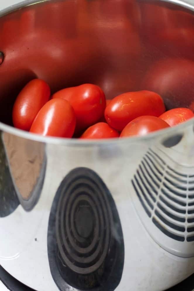 Large stock pot half full of roma tomatoes
