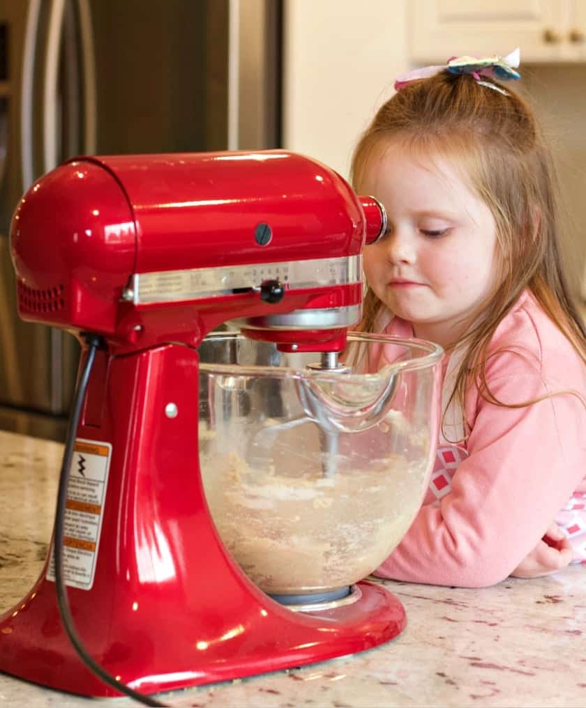 Ellie watching the cherry red Kitchen aid mixer work.