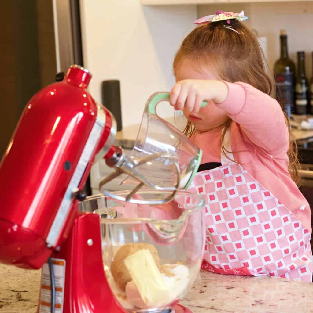 Three year old Ellie Adding ingredients into the kitchen aid work bowl
