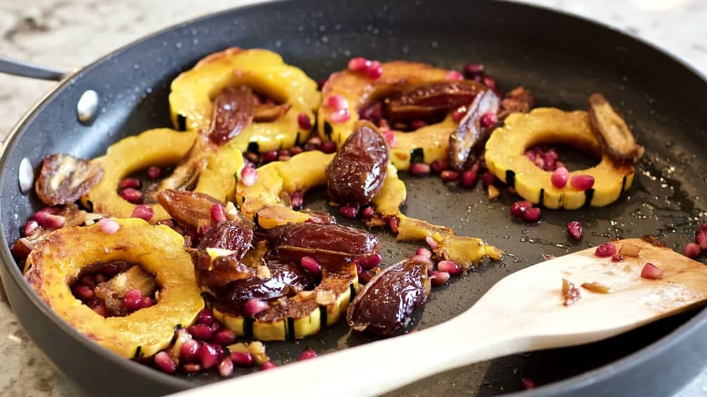 Delicata Squash Saute' at serving in a skillet with a wooden server.