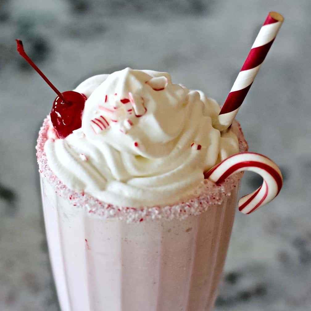 peppermint milkshake garnish. whipped cream, a candied cherry, crushed peppermint candy, a mini candy cane and a candy cane paper straw.