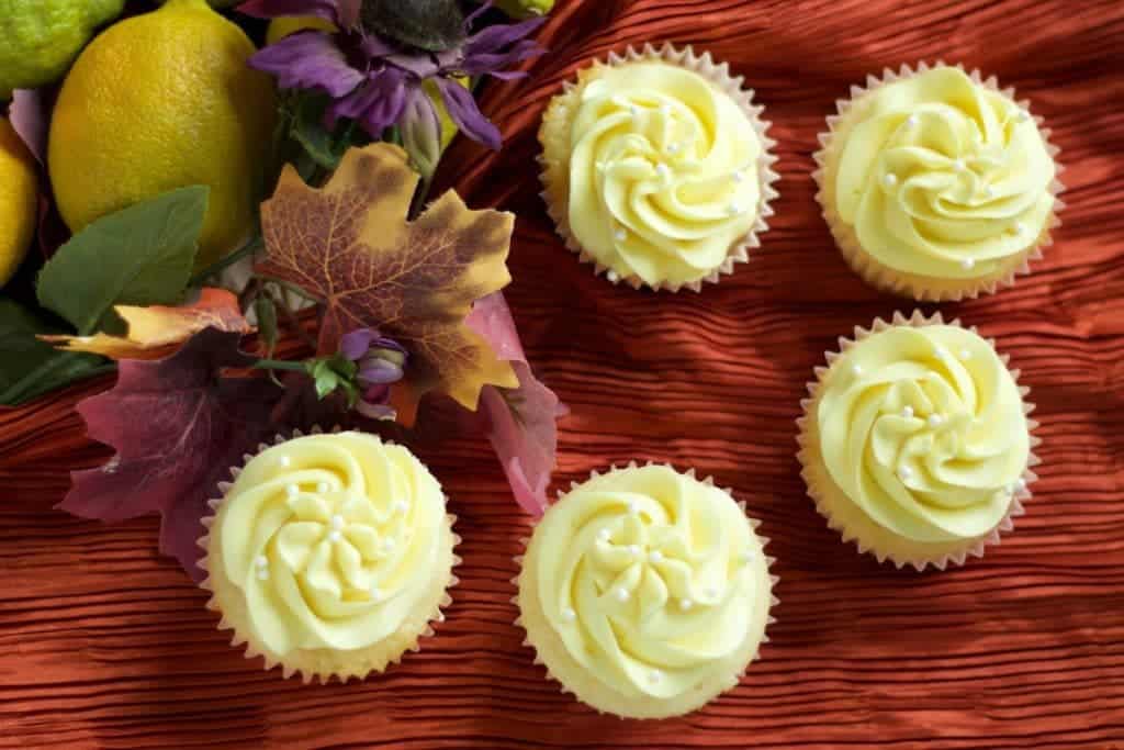 Lemony Lemon cupcakes on a burnt orange shiny fabric with lemons and fall leaves. 