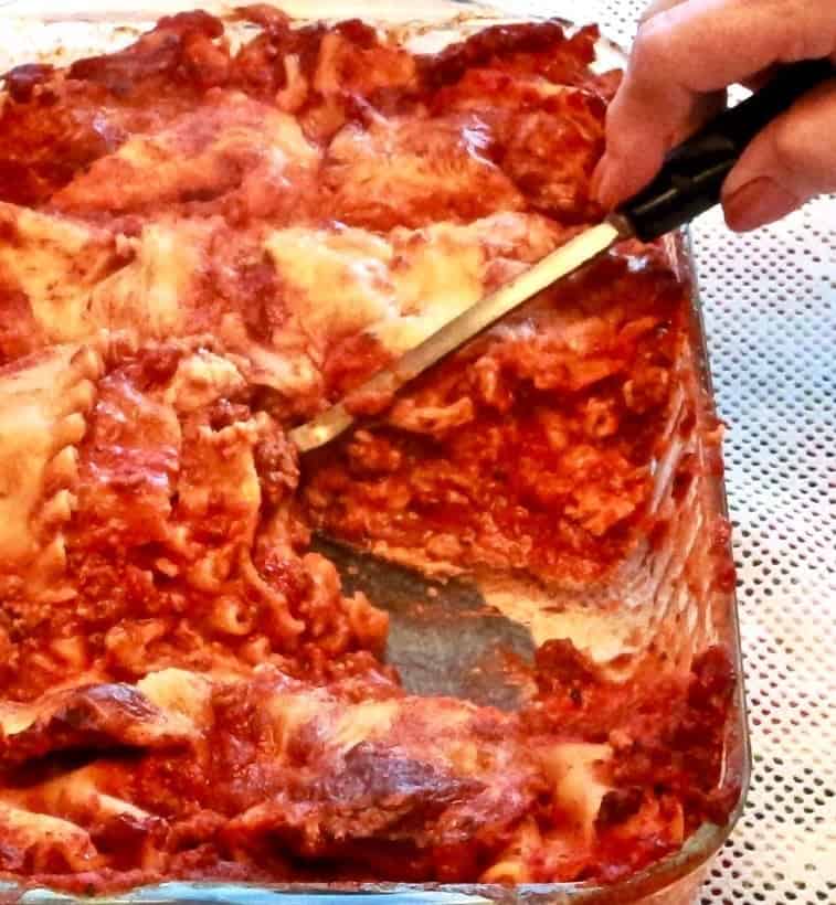 shown is our Homemade five cheese Lasagna recipe in a casserole with a serving spoon