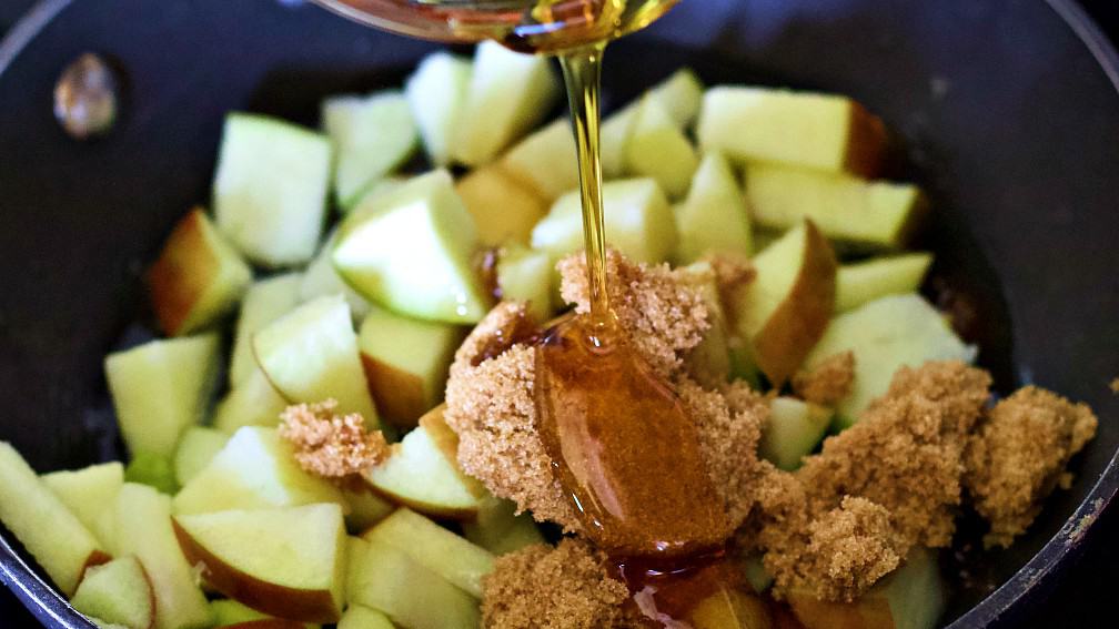 adding topping ingredients to skillet