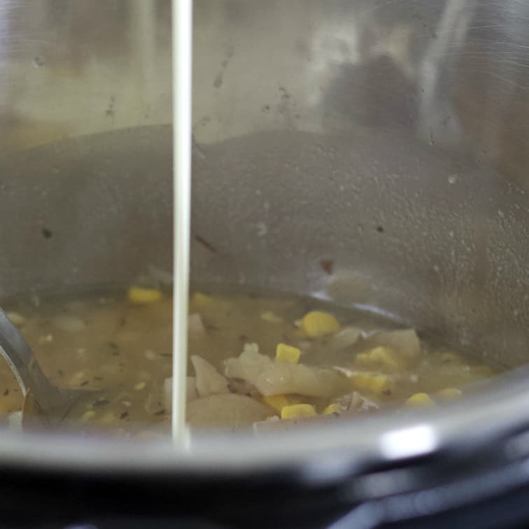 adding cream to corn chowder