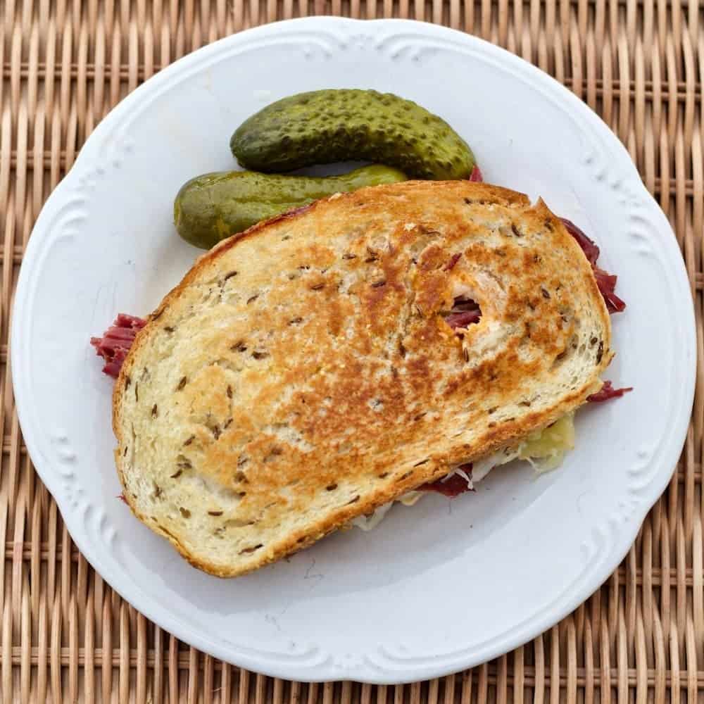 Reuben Sandwich is a Favorite American Sandwich. Piquant combination of Swiss Cheese, corned beef, sauerkraut and delicious dressing