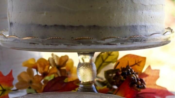 A lovely Carrot Cake with Pineapple and Pure maple Syrup on a cake stand surrounded by fall leaves