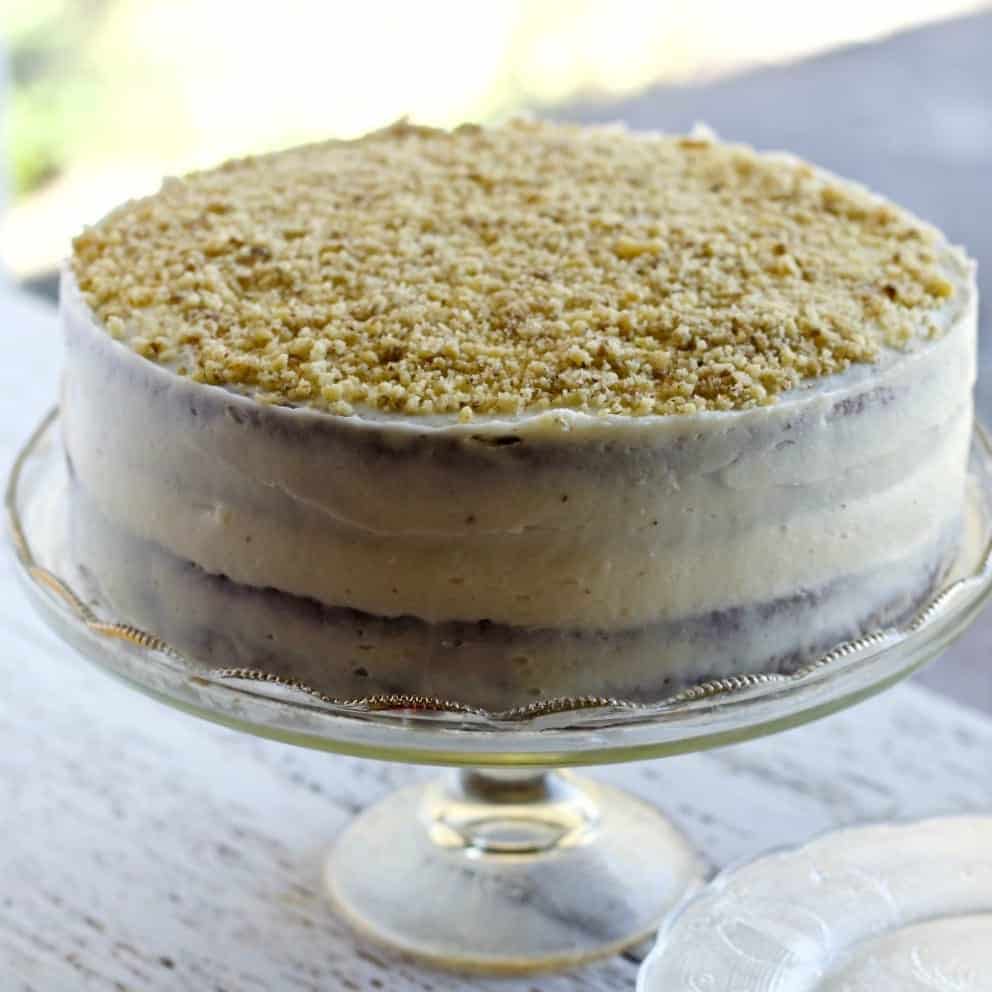 Carrot Pineapple Cake is a moist carrot cake sweetened with pure maple syrup and crushed pineapple. The cake is frosted with cream cheese frosting and garnished with chopped nuts.
