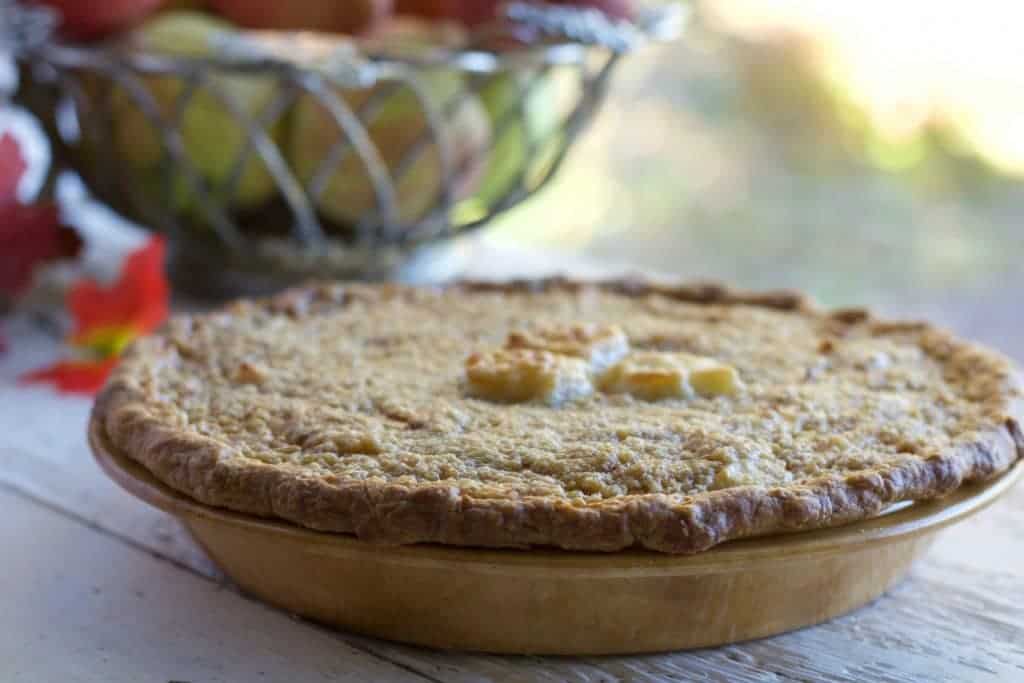 Sour Apple Pie in front of a bowl of apples
