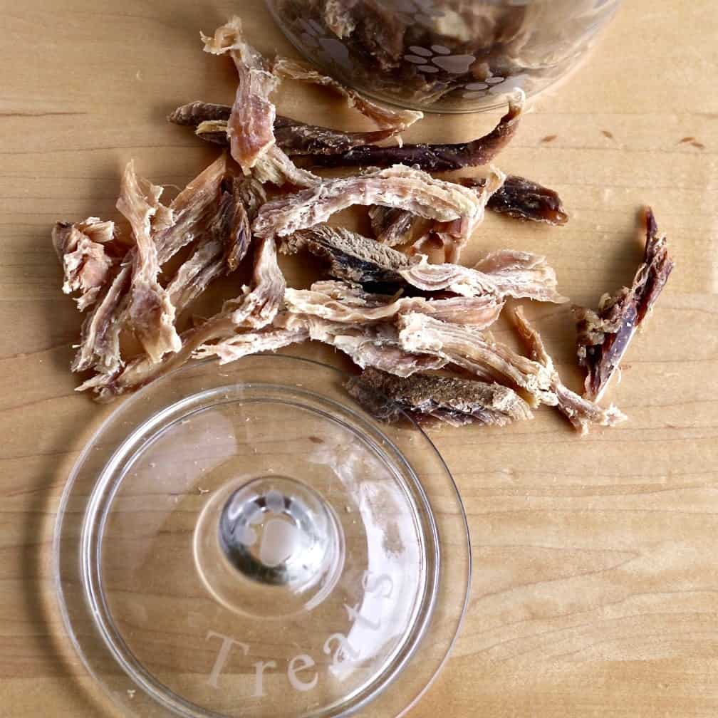 Turkey Jerky dog treats arranged around a treat jar lid.