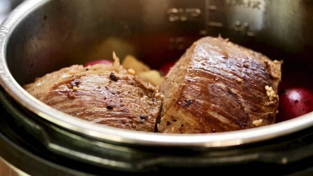 Roast beef braised and laid on top of the broth and veggies in the instant pot. Ready to cook.