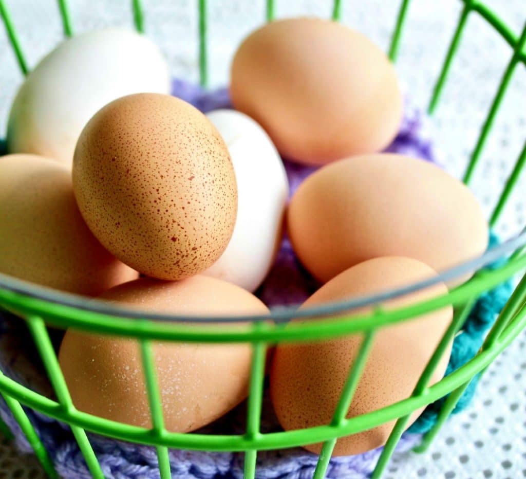 Free range Chicken Eggs in a green wire basket.
