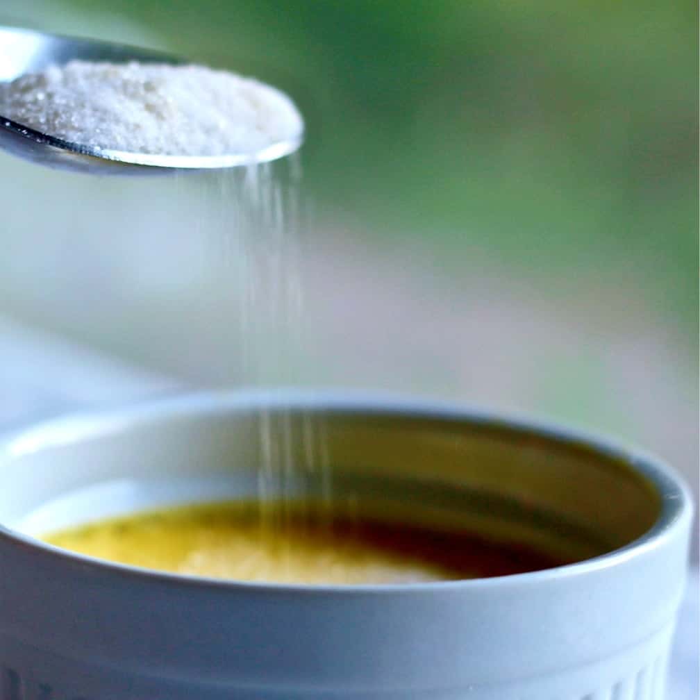 Sprinkling sugar over custard for Creme Brûlée