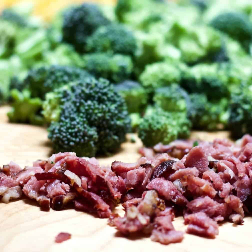 Cooked chopped bacon and fresh broccoli ready to cook.
