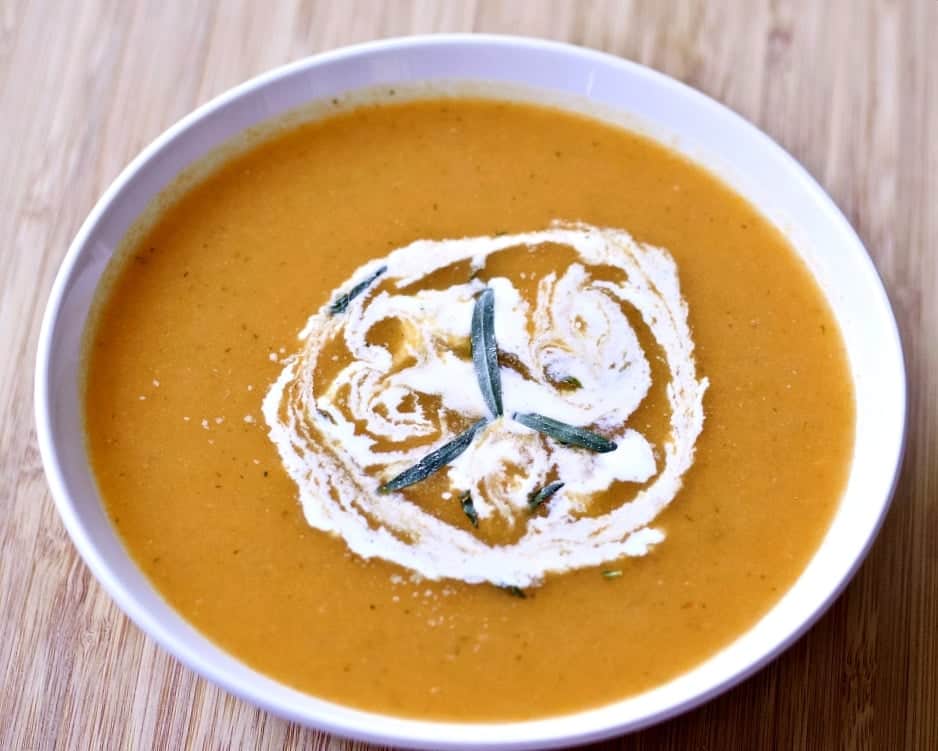 Carrot Tarragon Soup 4 Carrot Tarragon Soup garnished with fresh tarragon and cream in a white bowl