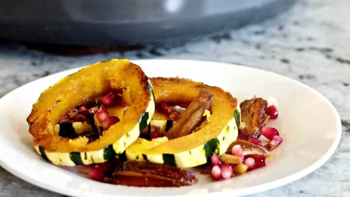 Delicata Squash Saute' on a white plate with a skillet full of this recipe in the background.