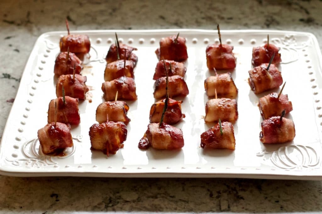 bacon wrapped water chestnuts on a white serving tray