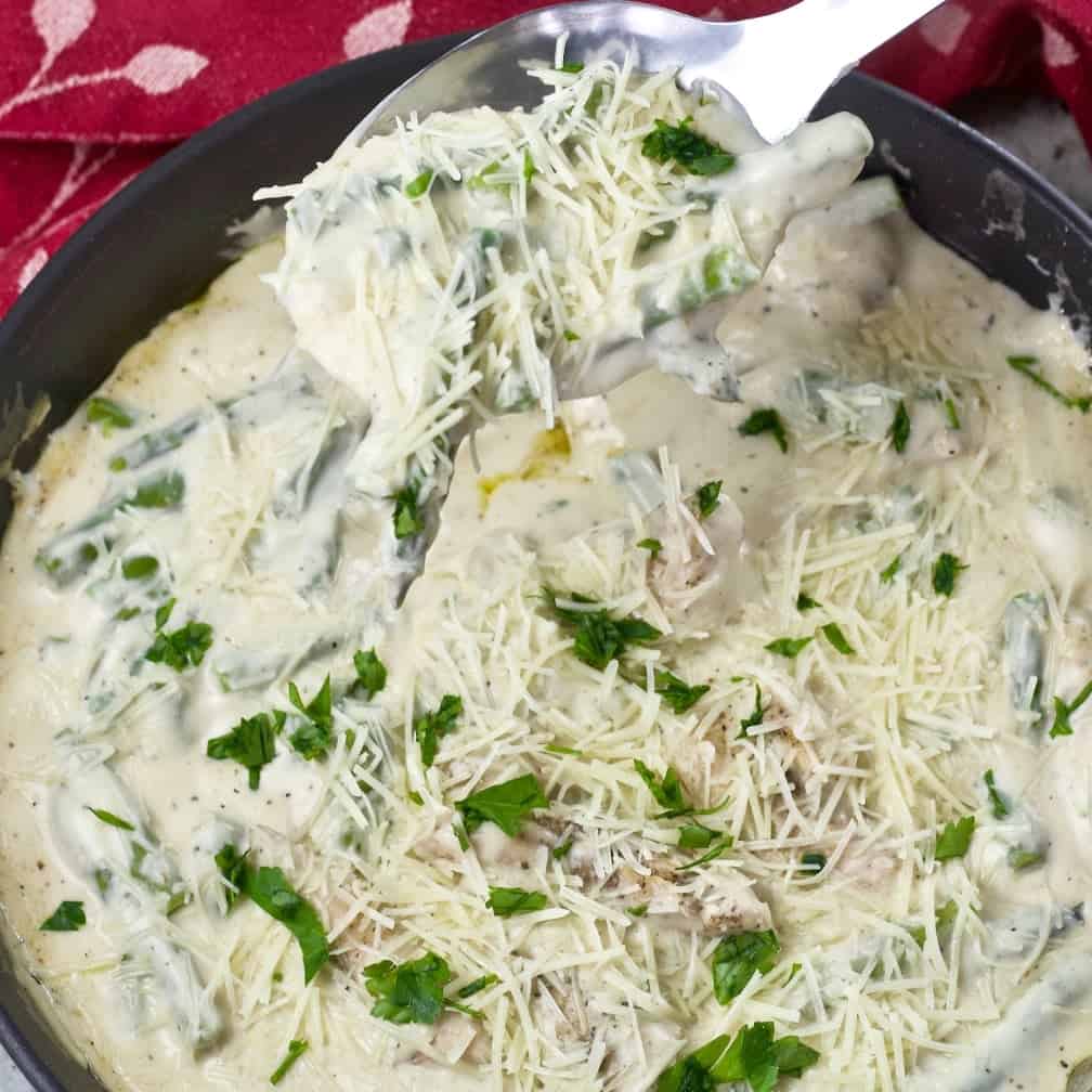 Low Carb Chicken Alfredo Skillet Dinner in a skillet spooned up