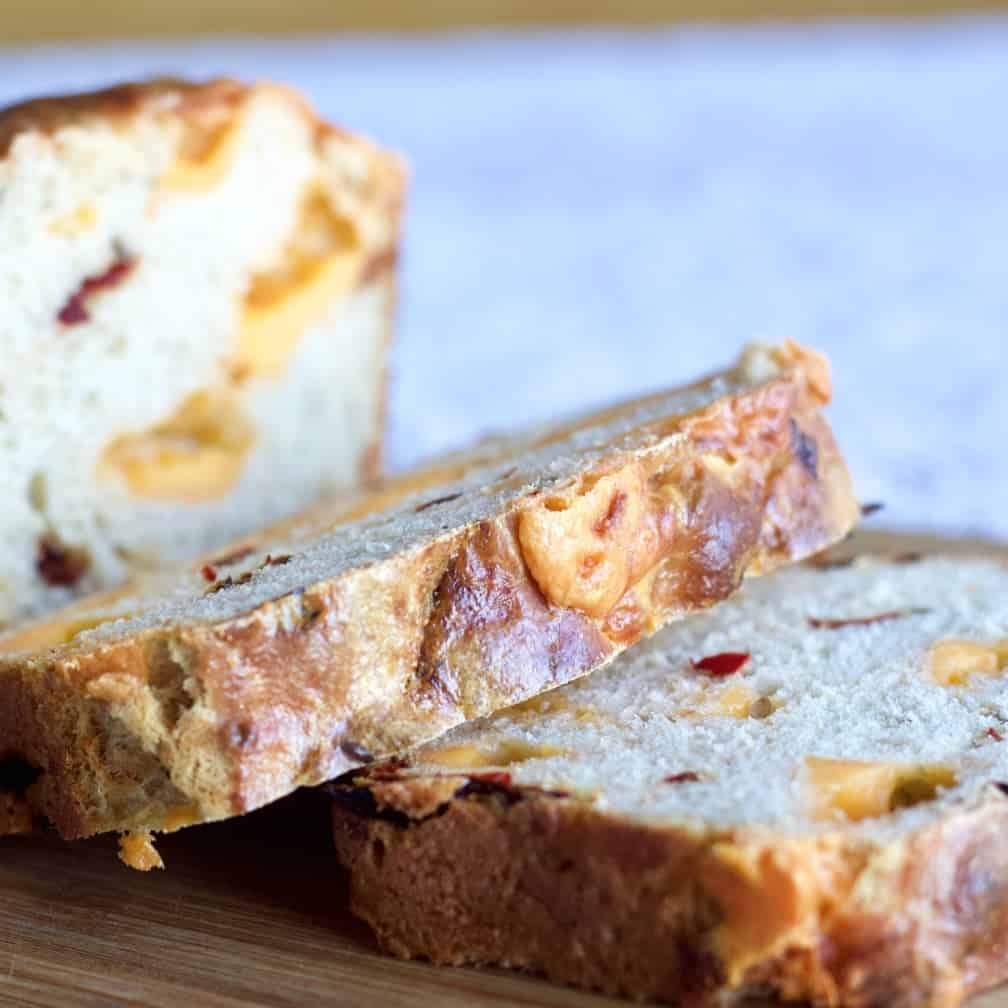 Sourdough Batter bread with cheese and peppers cut on a bread board.