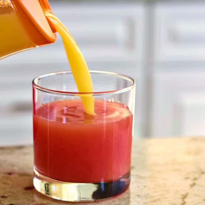 pouring orange juice into Sex on the Beach Drink