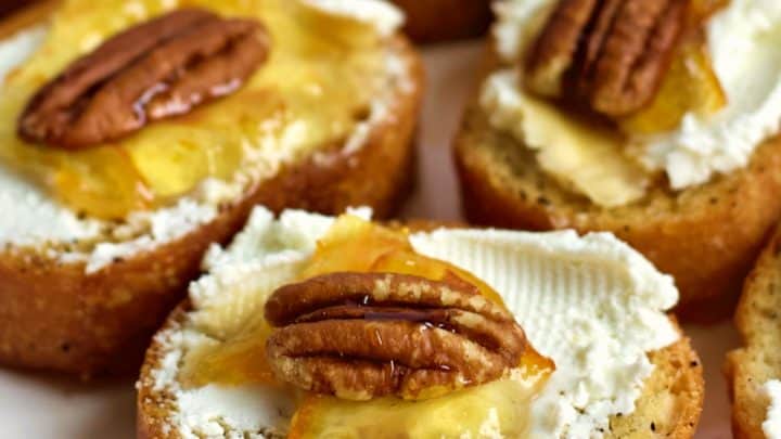 Goat cheese crostinis with marmalade on a party tray.