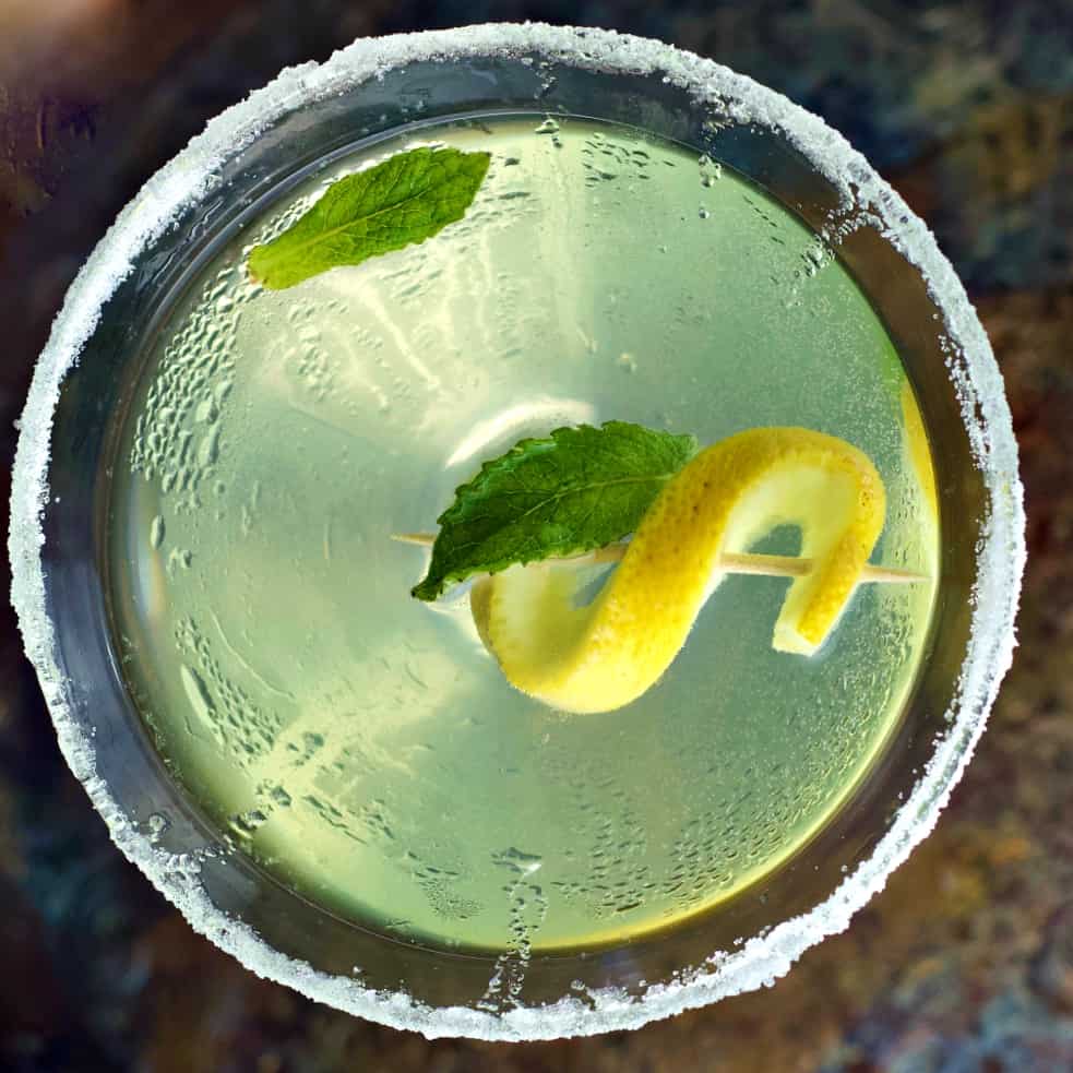 lemon drop martini top down shot with lemon twist and mint leaves for garnish
