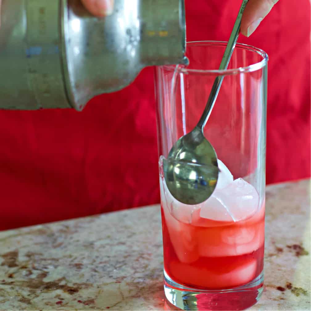 pouring the vodka/lemon layer into the red white and blue vodka drink.