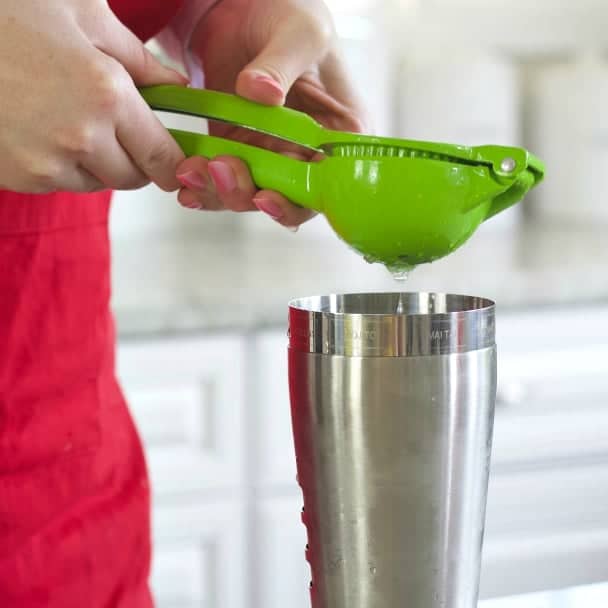 Squeezing a lime into the cocktail shaker