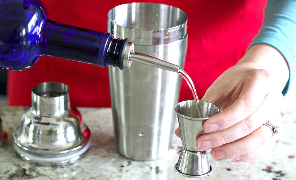 measuring the vodka for the shaker. red white and blue vodka drink