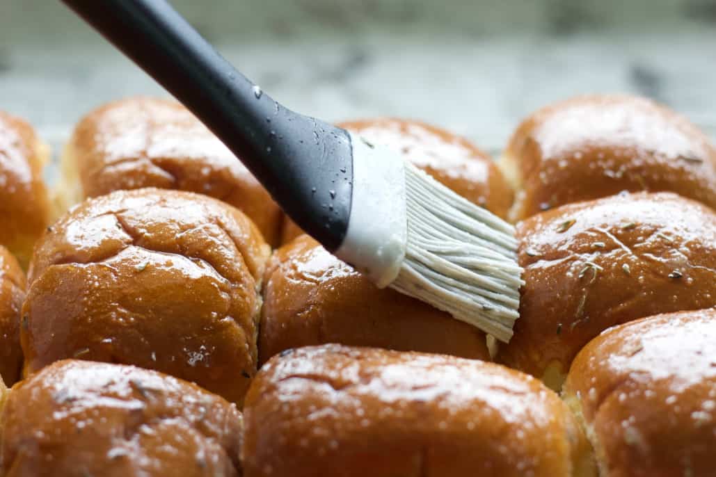 Basting the sliders with herbed butter