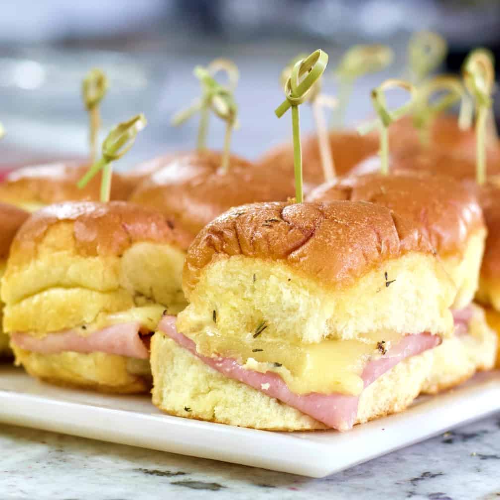 sliders with bamboo picks on a tray.