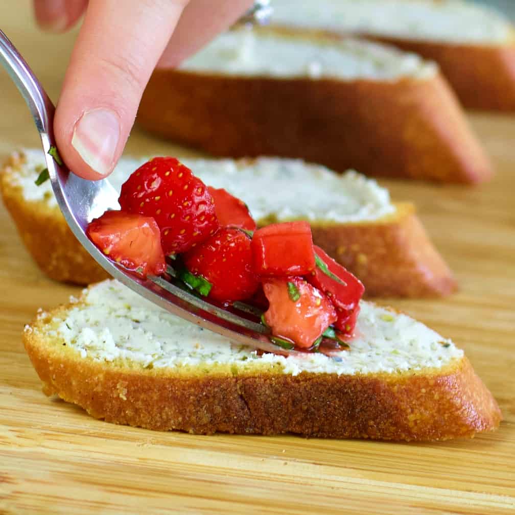 Loading the topping on strawberry bruschetta