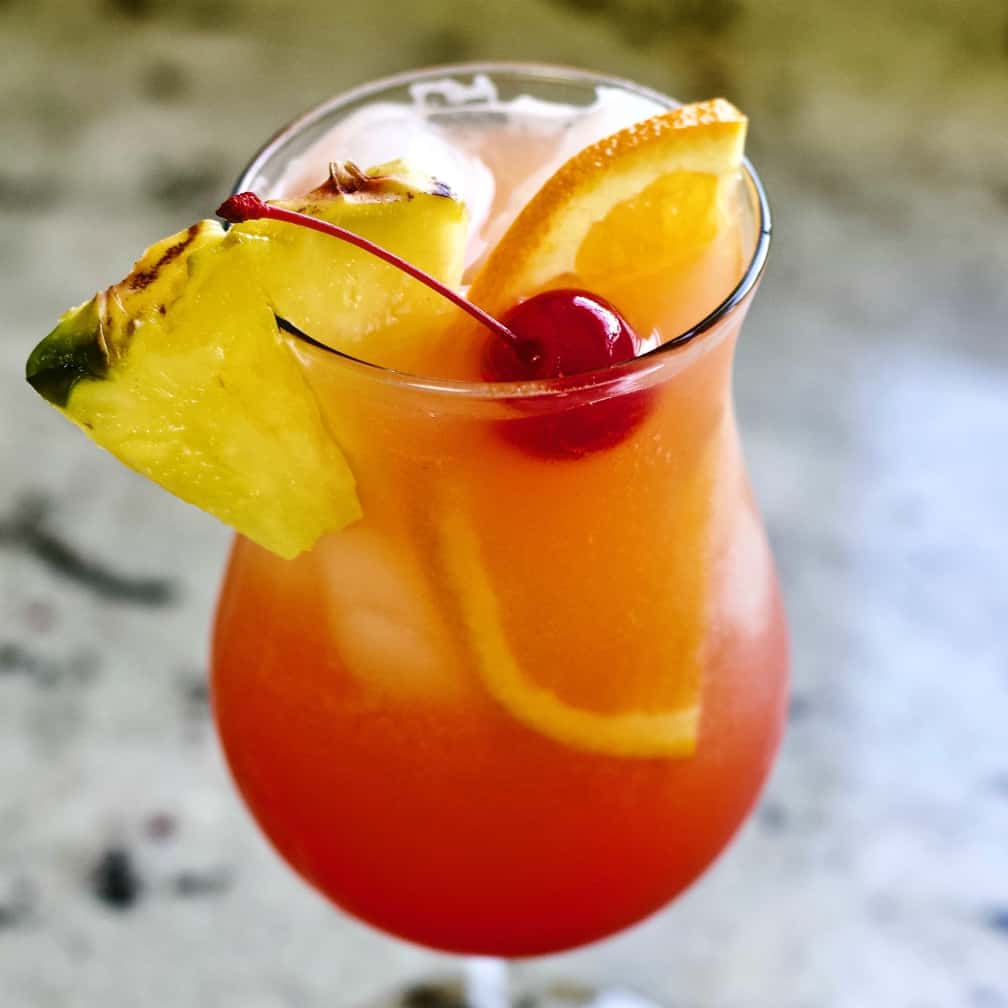 Mai Tai in the fruity mixed drink form. Garnished with a pineapple wedge. half orange slice and maraschino cherry