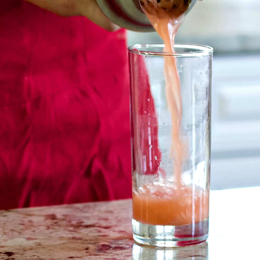 pouring rum punch into a glass