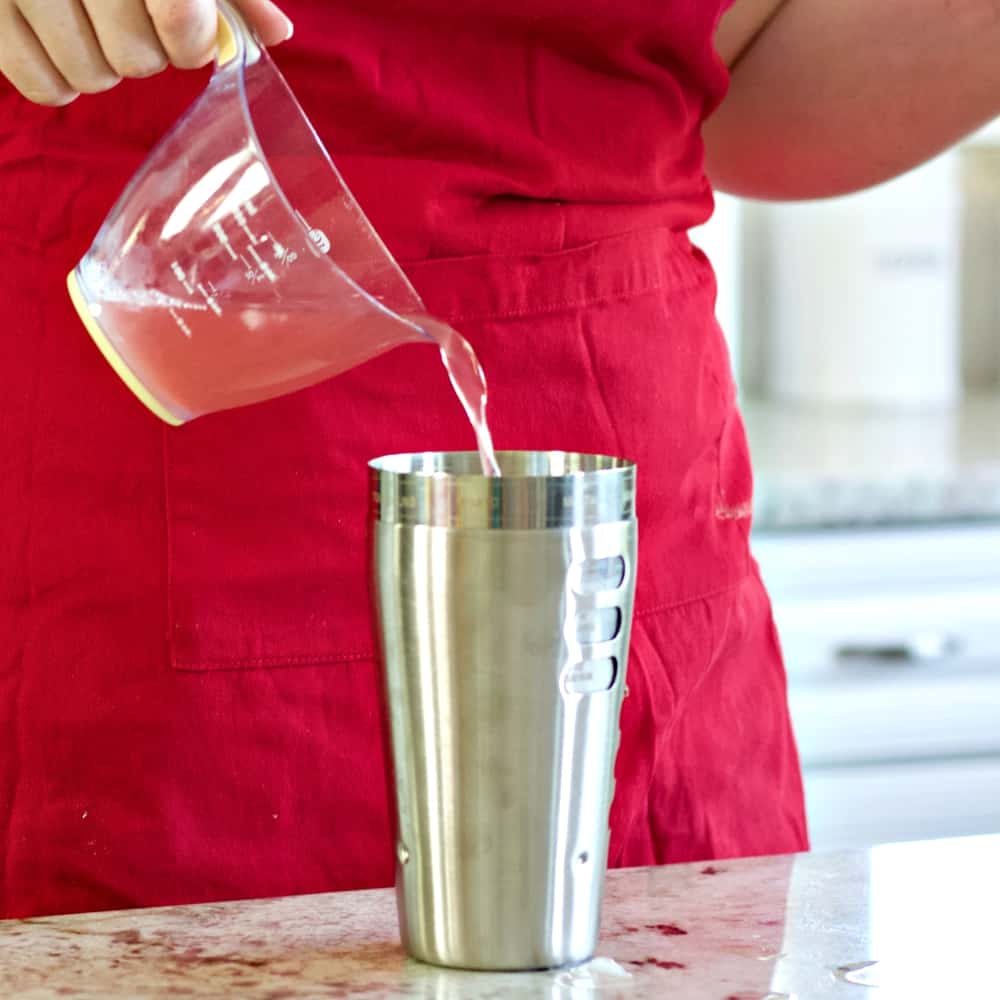 pouring in the fruit juice-rum punch