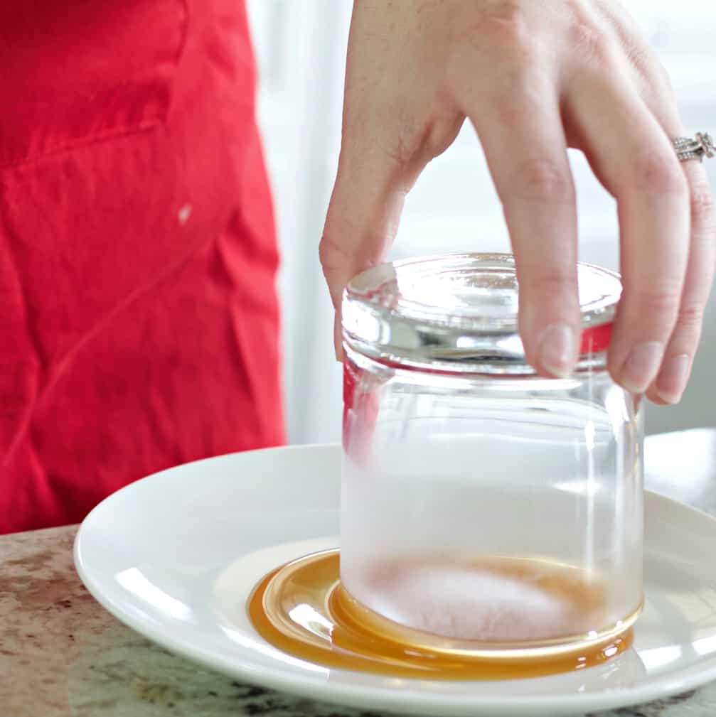 Rimming a whiskey glass with caramel for salted caramel whiskey drink