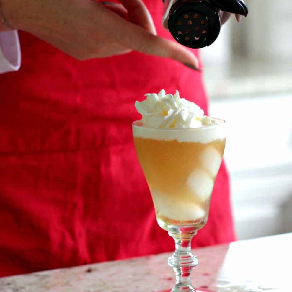 sprinkling nutmeg over the caramel vanilla cream soda cocktail
