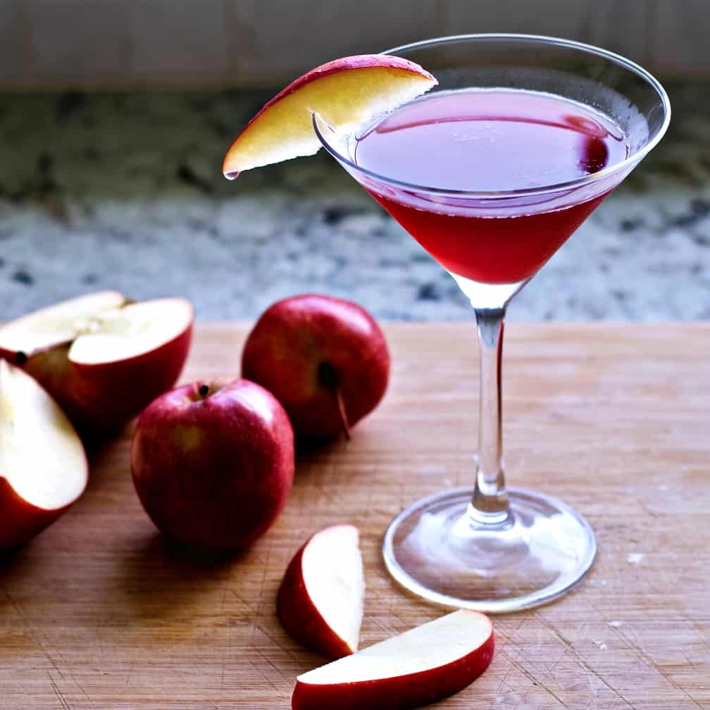Apple drink with apples on a board.