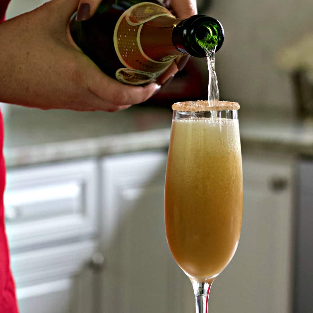 pouring sparkling white wine into pear juice