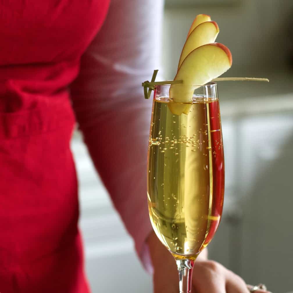 apple cider mimosa garnished with apple slices