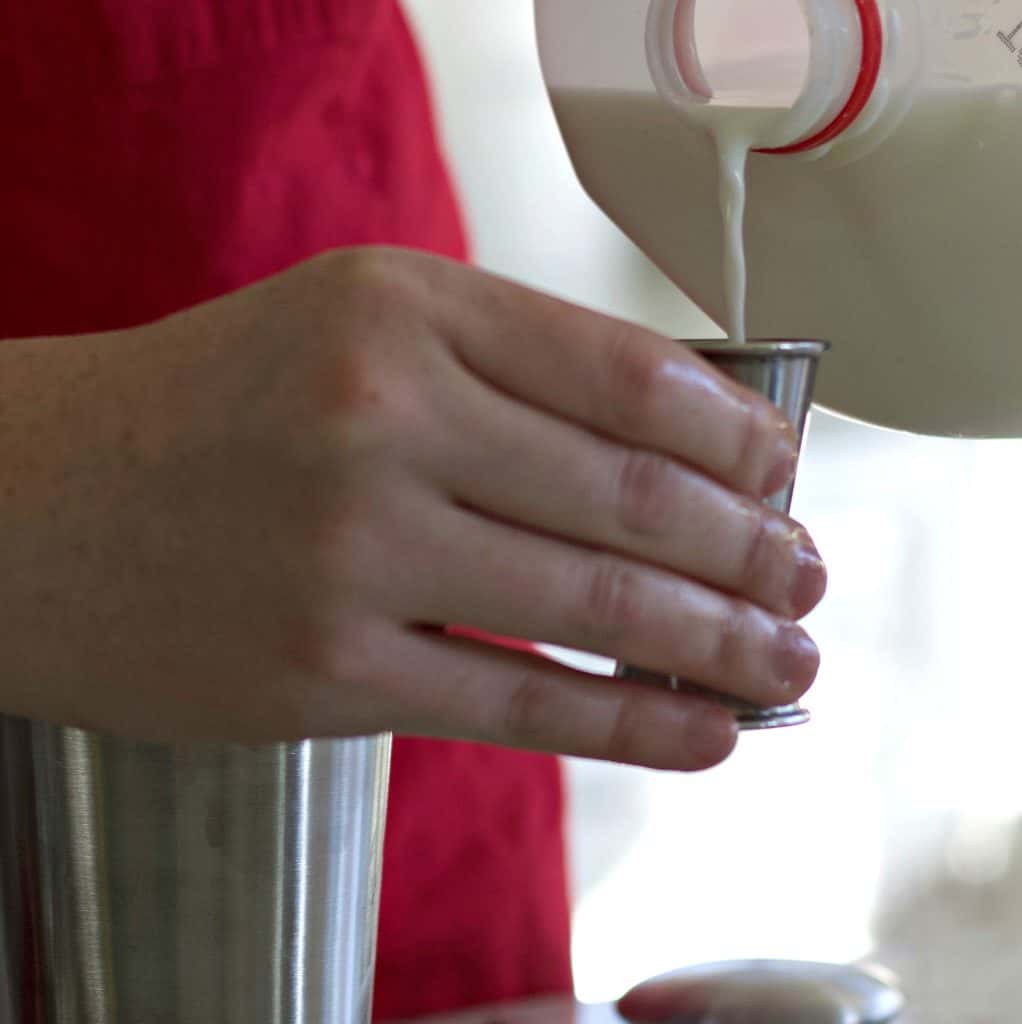 measuring milk into a jigger