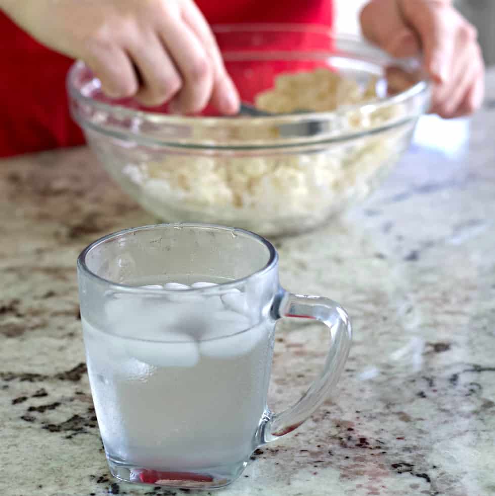ice water next to a mixing bowl with dough