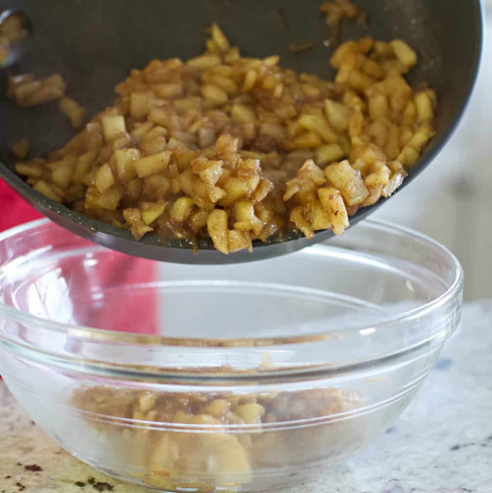 Homemade Apple Turnover Recipe with Puff Pastry 12 pouring hot cooked apples into bowl