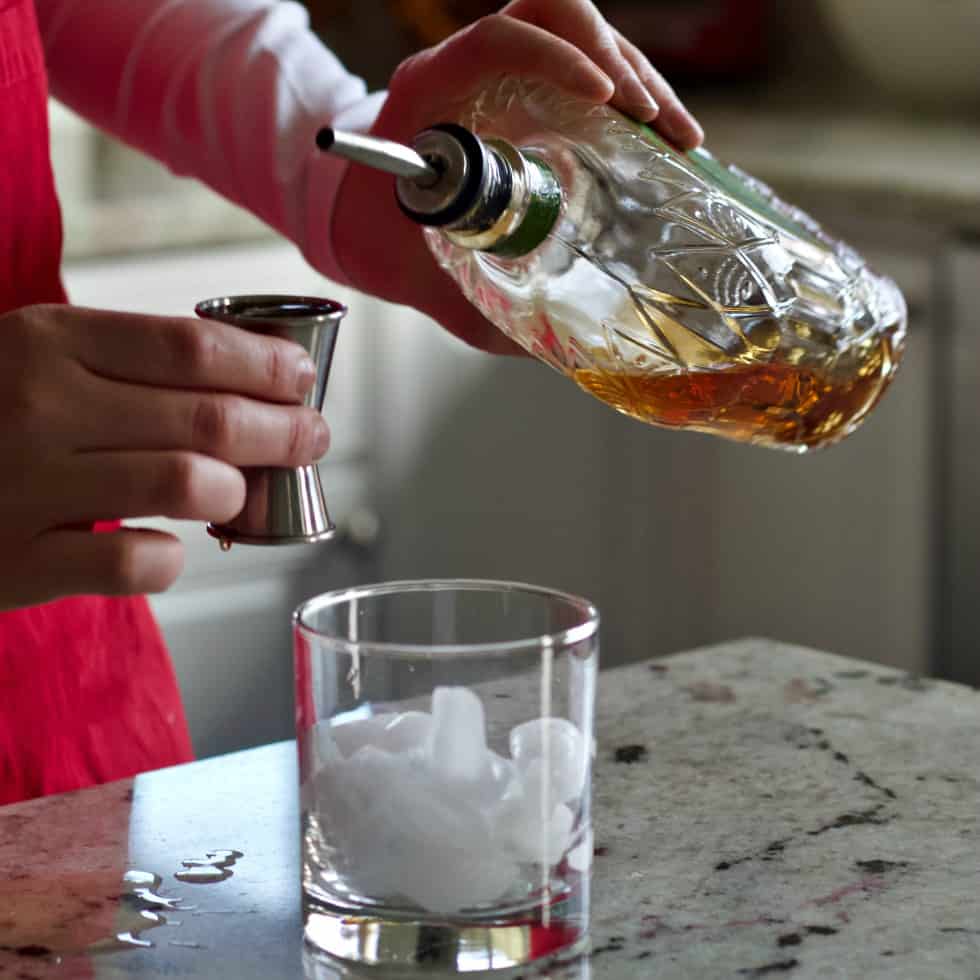 Pouring Crown apple Whiskey into a jigger