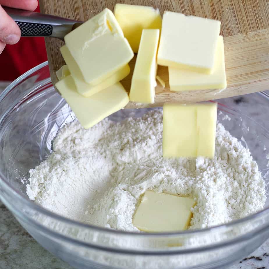 Sliding butter chunks into the flour.