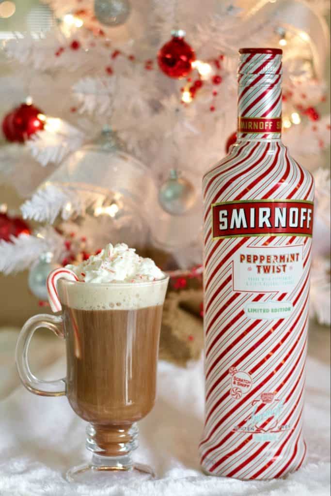 Smirnoff Peppermint Twist Vodka and peppermint hot chocolate stinger in front of a white christma tree.