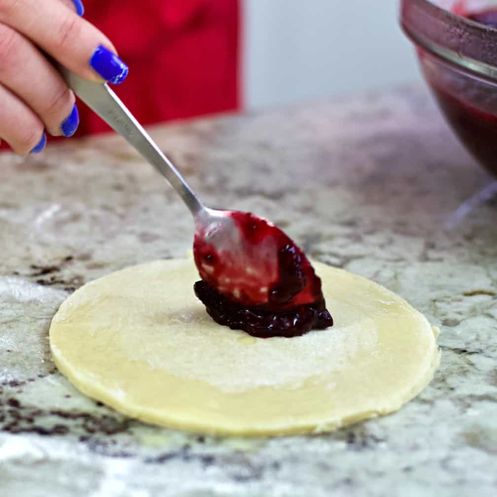 dropping blackberry filling onto dough. Hand pies